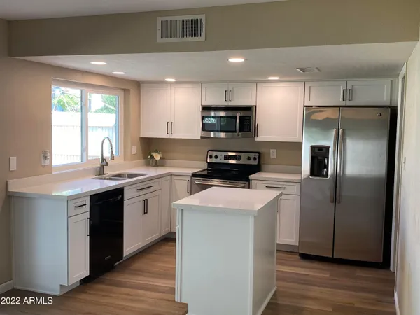 a kitchen with stainless steel appliances a refrigerator sink and microwave