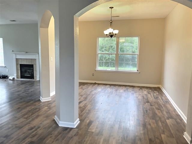 871 Ruby Creek Cove Memphis, TN 38109 - Photo 4 of 16 an empty room with wooden floor fireplace and windows