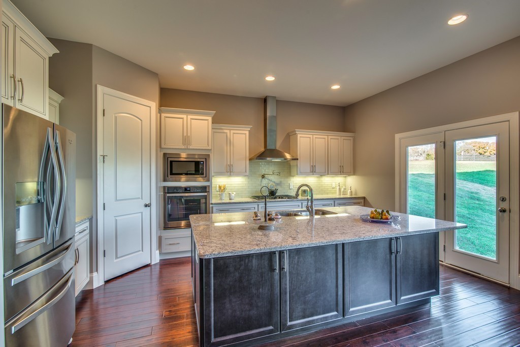 1026 October Park Way Franklin, TN 37067 - Photo 12 of 27 a kitchen with stainless steel appliances granite countertop a sink a stove and a refrigerator