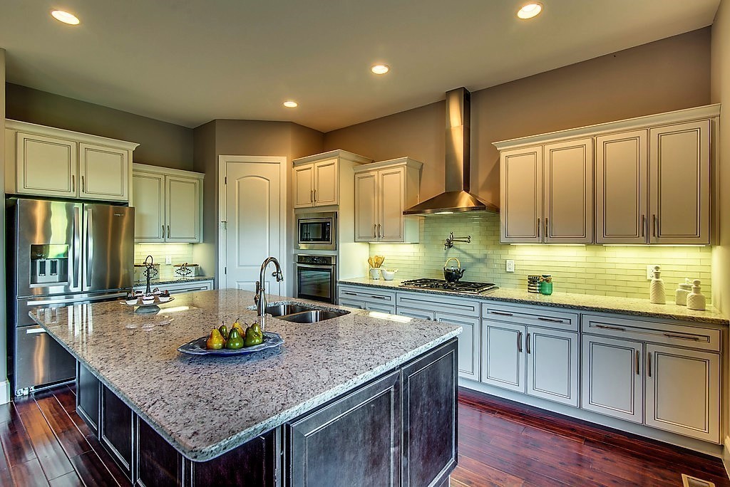 1026 October Park Way Franklin, TN 37067 - Photo 13 of 27 a kitchen with stainless steel appliances granite countertop a sink dishwasher stove and refrigerator with wooden floor
