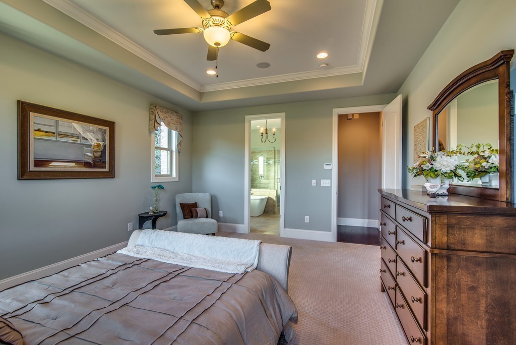 1026 October Park Way Franklin, TN 37067 - Photo 16 of 27 a bedroom with a large bed and a chandelier