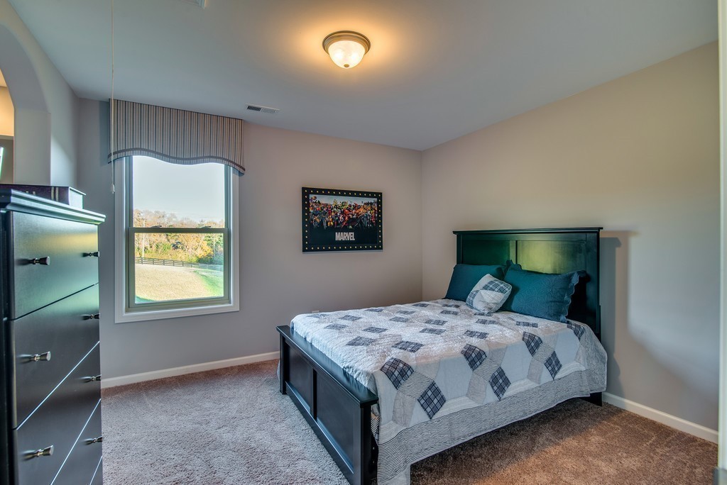 1026 October Park Way Franklin, TN 37067 - Photo 26 of 27 a bedroom with a bed and a dresser next to a window