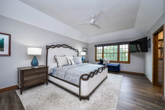 a spacious bedroom with a bed lamp closet and window