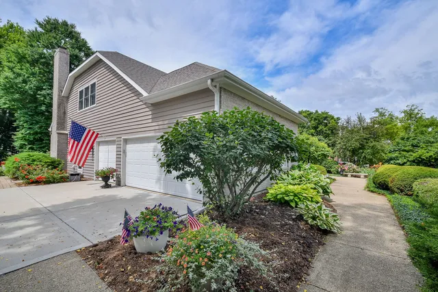 a front view of a house with a yard and potted plants