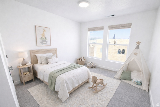 11014 South Lake Run Road, Unit 146 South Jordan, UT 84009 - Photo 14 of 22 Bright room featuring two windows with woven shades, light gray carpet, and white painted walls