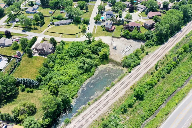 an aerial view of residential houses with outdoor space and trees