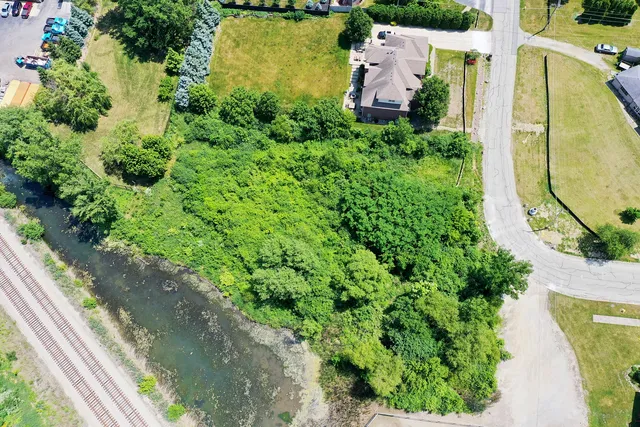 an aerial view of a house with a yard and lake view