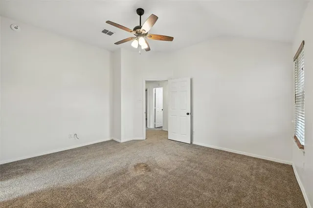 an empty room with a window and a fan