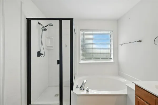 a white bath tub sitting next to a shower