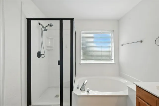 a white bath tub sitting next to a shower