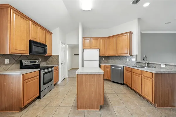 a kitchen with stainless steel appliances granite countertop a stove top oven a sink dishwasher and a microwave oven on the blue kitchen countertops