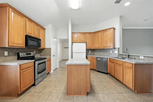 a kitchen with stainless steel appliances granite countertop a stove top oven a sink dishwasher and a microwave oven on the blue kitchen countertops