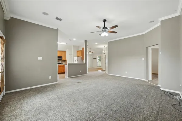 a view of a big room with a ceiling fan and entryway