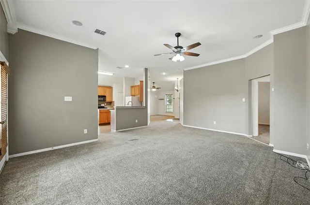 a view of a big room with a ceiling fan and entryway