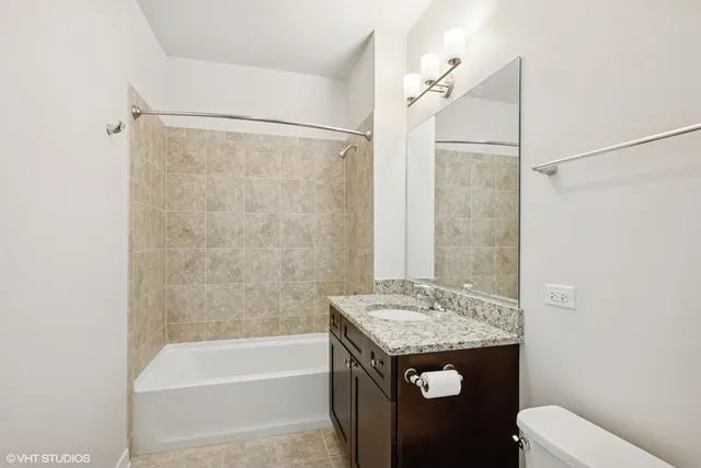 a bathroom with a granite countertop sink a toilet and shower
