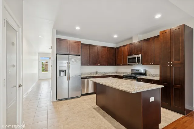 a kitchen with stainless steel appliances granite countertop a refrigerator stove microwave and sink