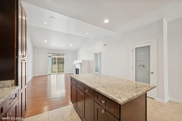 a kitchen with granite countertop cabinets and wooden floor