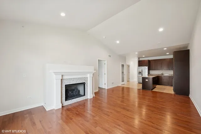a view of empty room with wooden floor and fireplace