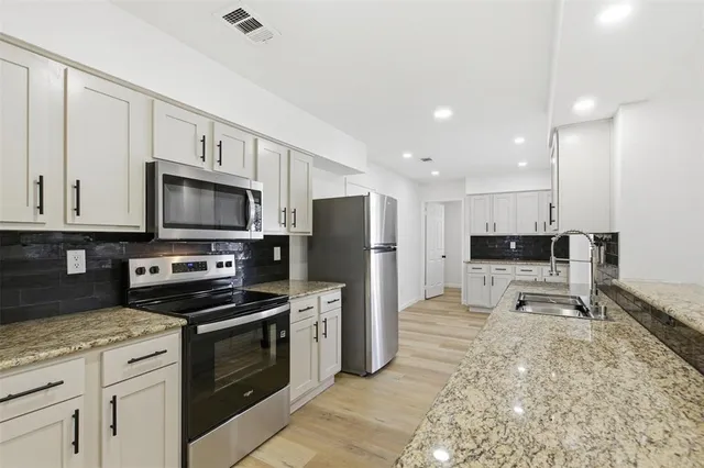 a kitchen with a sink a microwave and refrigerator