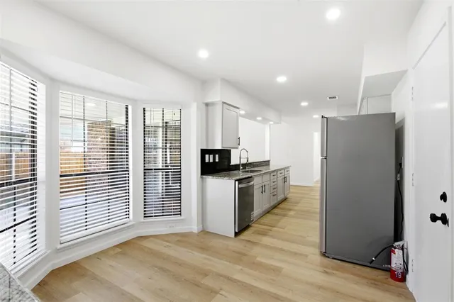 a kitchen with a refrigerator and a stove top oven