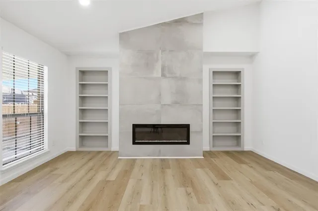 a view of an empty room with a fireplace and a window