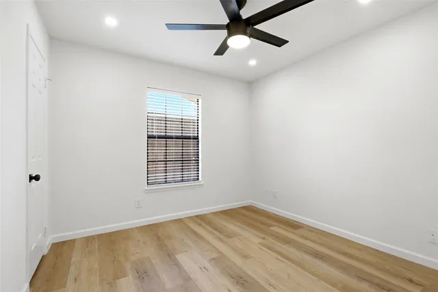 an empty room with a window and a ceiling fan