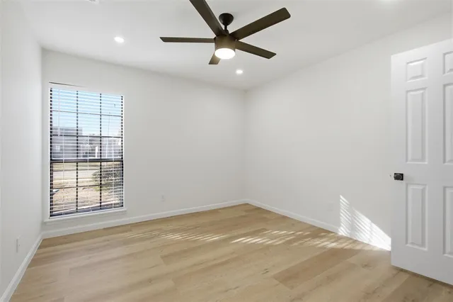 an empty room with a window and a ceiling fan