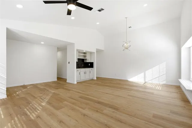 a view of empty room with wooden floor and ceiling fan