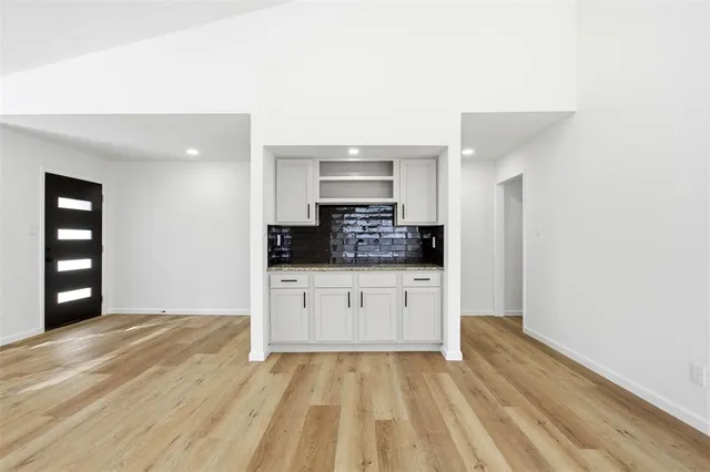 a kitchen with a white cabinets and window