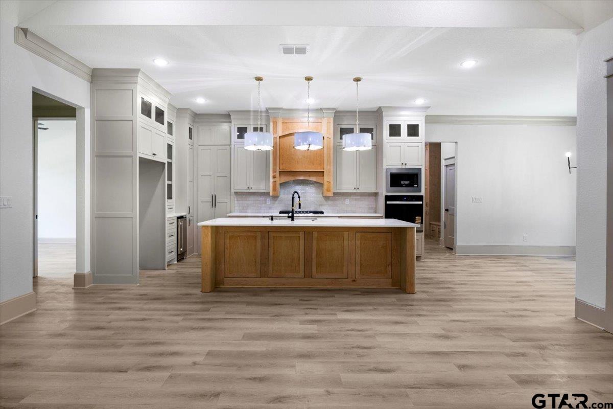 12336 Oak Grove Drive Lindale, TX 75706 - Photo 15 of 46 a large kitchen with stainless steel appliances kitchen island granite countertop a refrigerator and a stove top oven