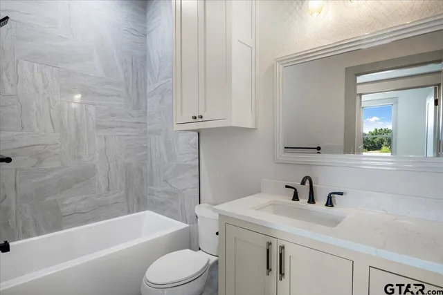 a bathroom with a sink a toilet and bathtub