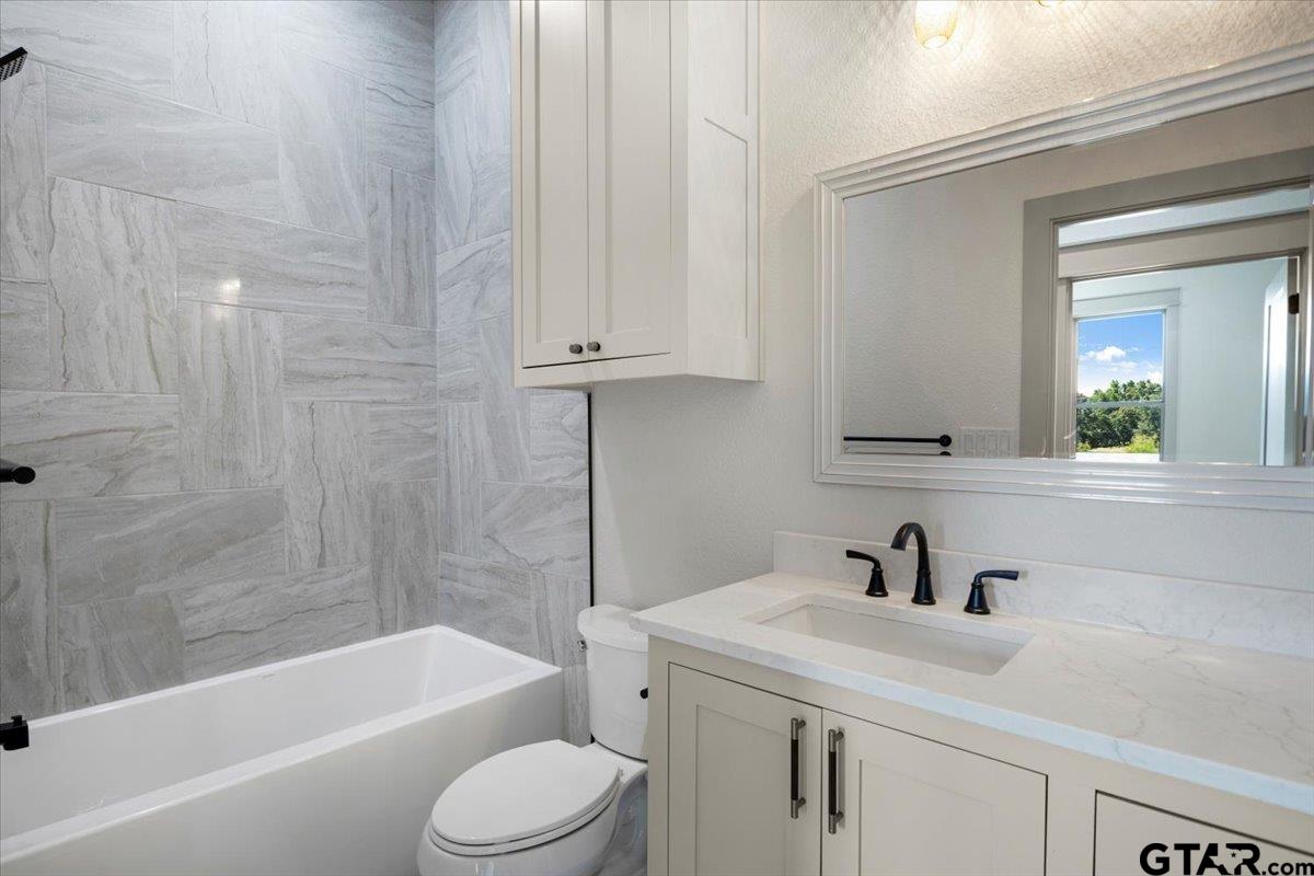 12336 Oak Grove Drive Lindale, TX 75706 - Photo 34 of 46 a bathroom with a sink a toilet and bathtub