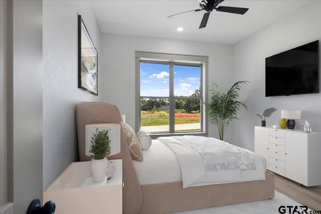a bedroom with a large bed and a flat tv screen on dresser
