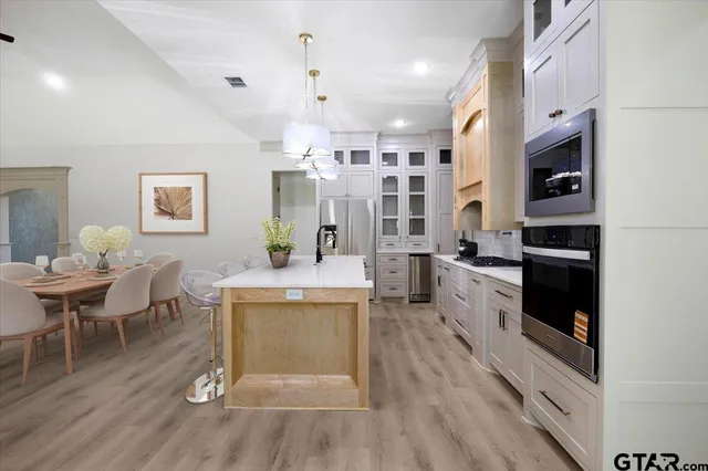 a living room with stainless steel appliances kitchen island granite countertop furniture wooden floor and a kitchen view
