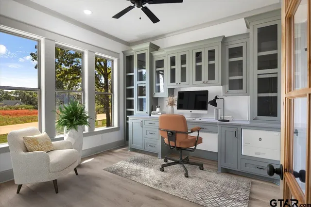 a view of a workspace with furniture and a window