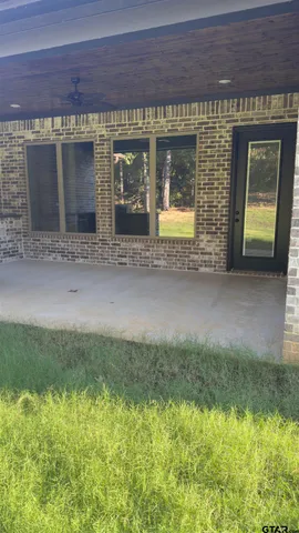 a view of a brick house with a small yard and a large window