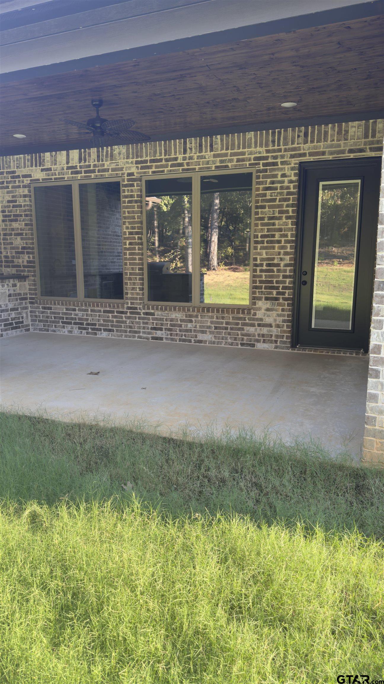 12336 Oak Grove Drive Lindale, TX 75706 - Photo 5 of 46 a view of a brick house with a small yard and a large window