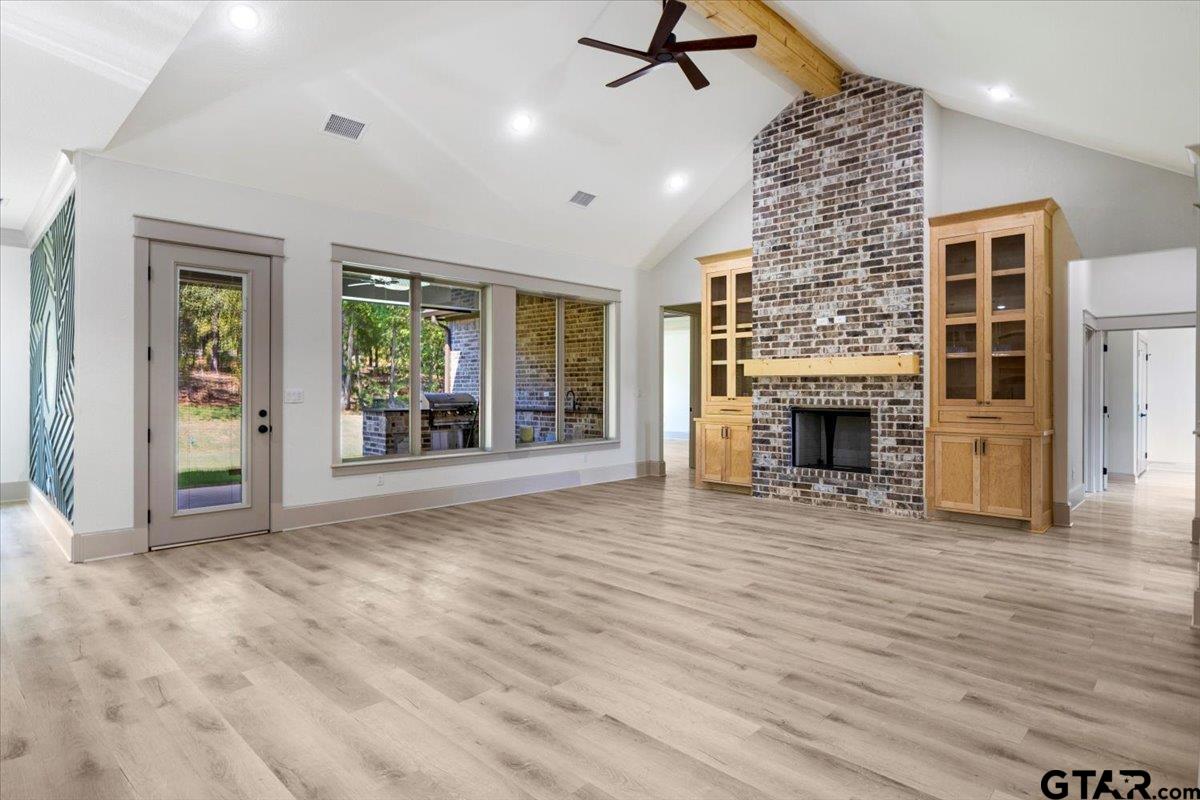 12336 Oak Grove Drive Lindale, TX 75706 - Photo 10 of 46 an empty room with windows fireplace and wooden floor
