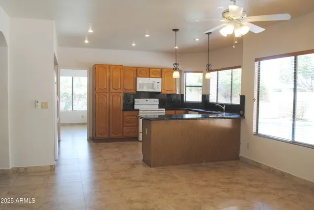 a kitchen with stainless steel appliances granite countertop a refrigerator a sink a stove and oven