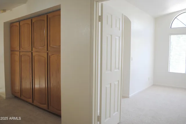 an empty room with a window and a chandelier