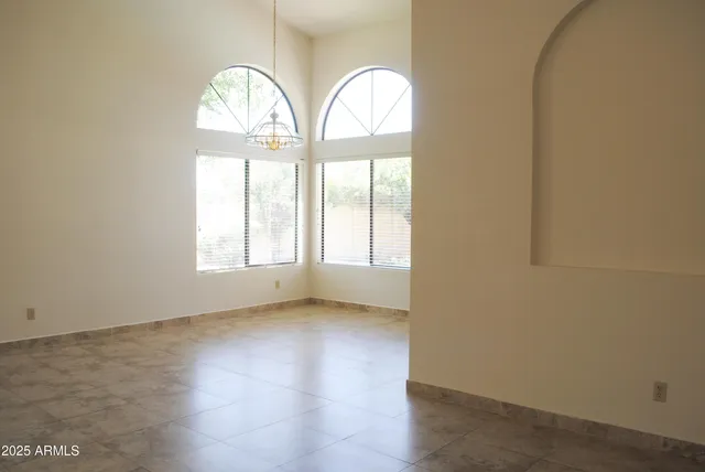 an empty room with wooden door mirror and windows
