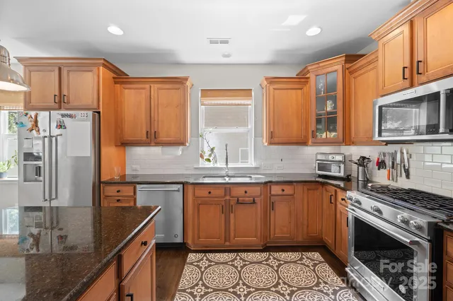 a kitchen with stainless steel appliances granite countertop a sink stove and refrigerator