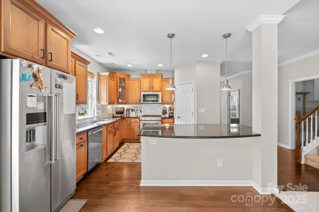 a large kitchen with stainless steel appliances kitchen island a large counter top and a refrigerator