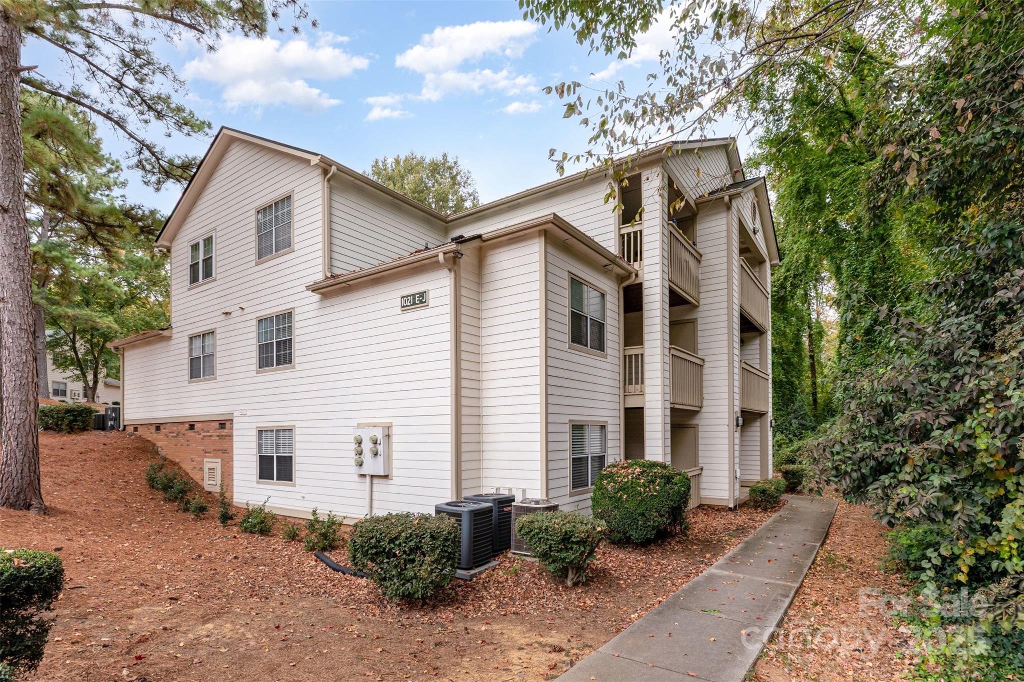 1021 Churchill Downs Court, Unit G Charlotte, NC 28211 - Photo 1 of 37 a view of a white house with a yard and potted plants