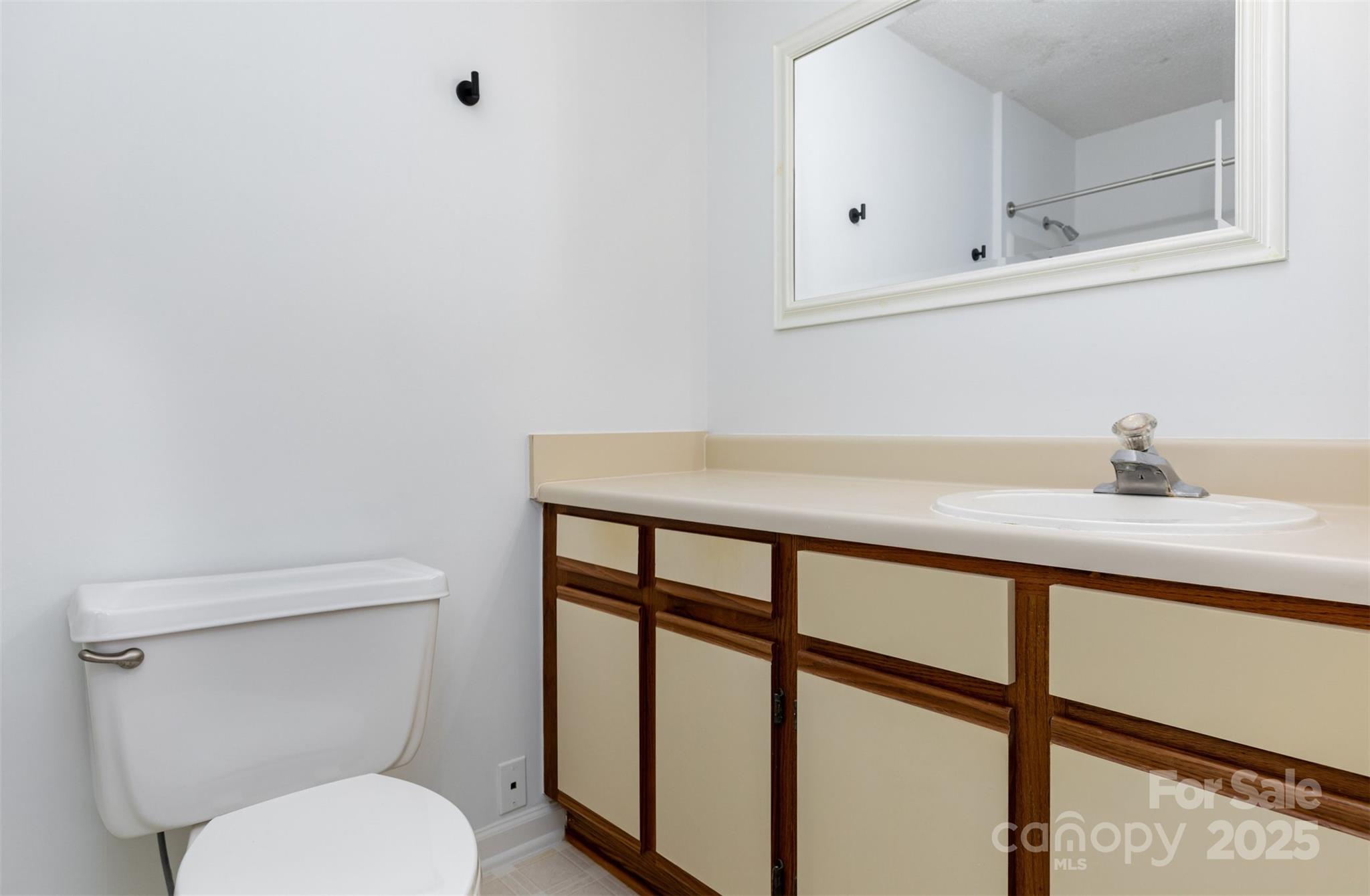 1021 Churchill Downs Court, Unit G Charlotte, NC 28211 - Photo 15 of 37 a bathroom with a toilet a sink and mirror
