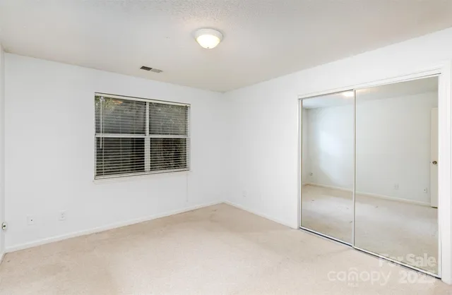 an empty room with windows and closet