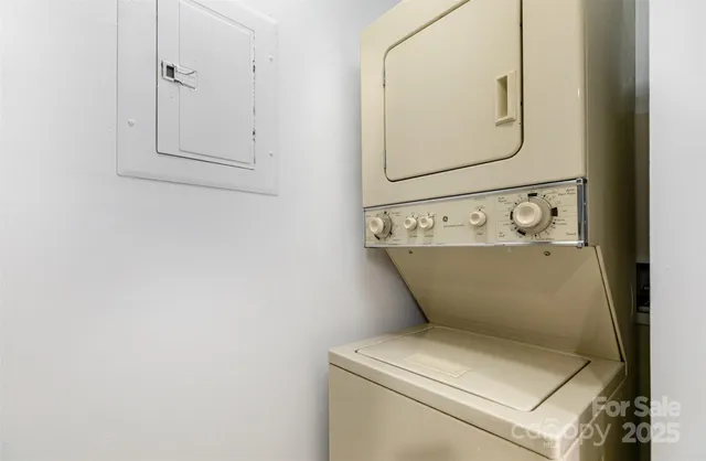 a utility room with dryer and white walls