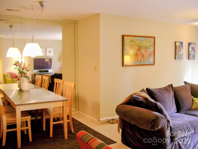 a living room with furniture kitchen view and a window