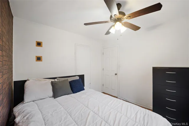 a bedroom with a bed and a ceiling fan