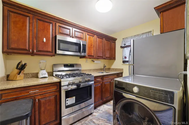 a kitchen with granite countertop a sink stove and cabinets